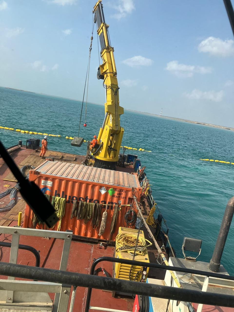 Cable handling spread on the lay barge. Deck crane and rigging positioned ahead of a floated section.