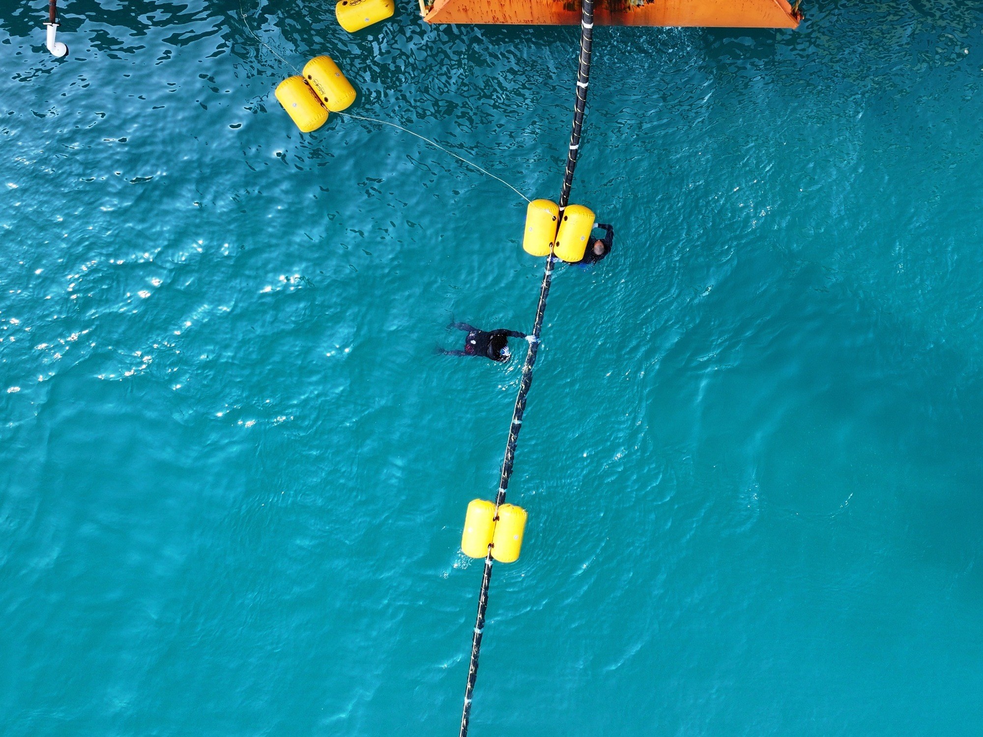 Divers working a subsea cable line during a live operation.
