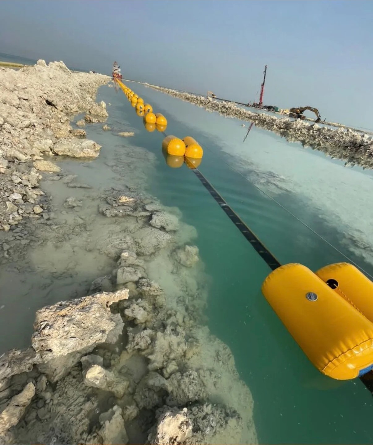Floated line positioned along a rock trench on the shore approach.