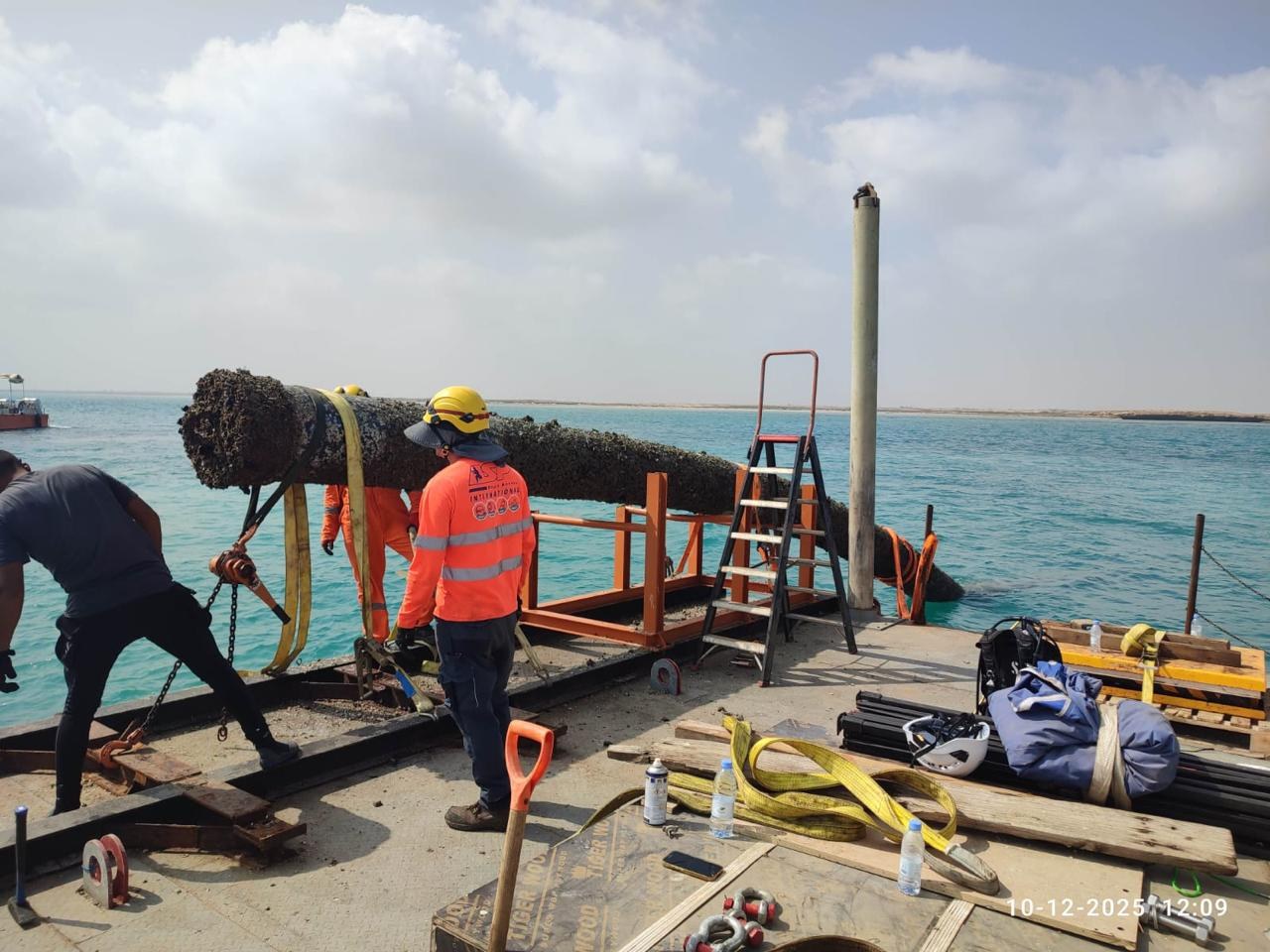 Recovered pipe section lifted to deck. Heavy marine growth after service on the seabed.